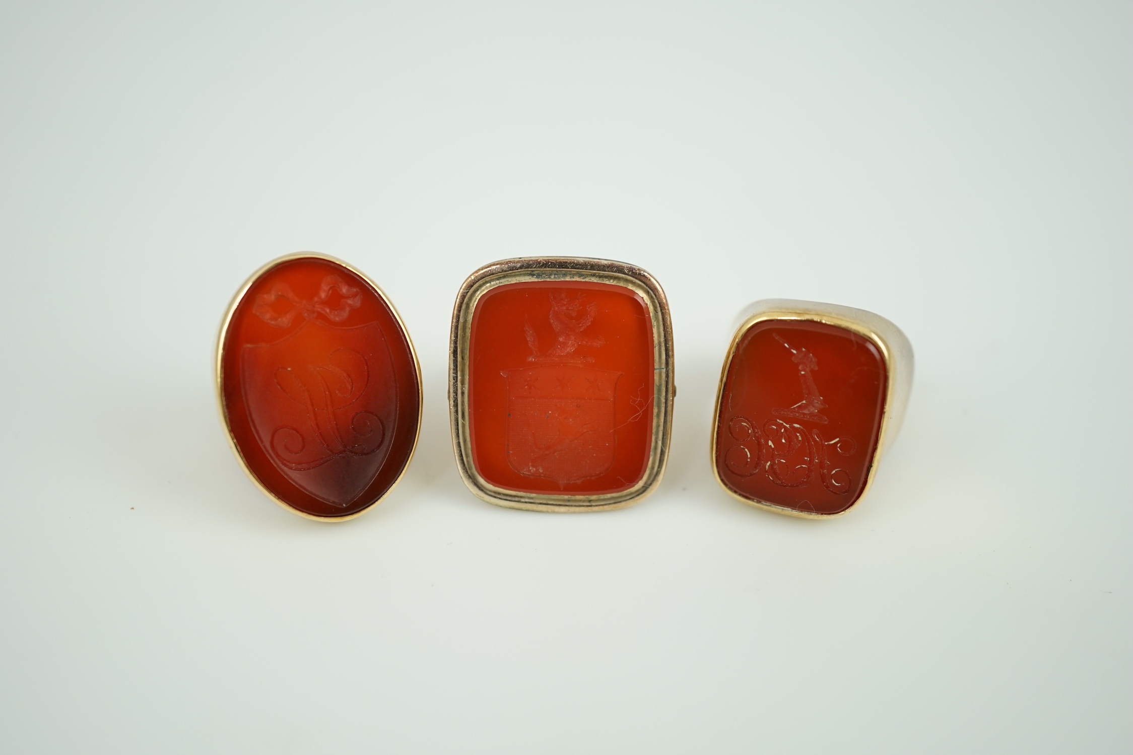 A Victorian 9ct and carnelian set intaglio ring, carved with a crest size L and two other similar yellow metal and carnelian intaglio ring, gross weight 35.8 grams.